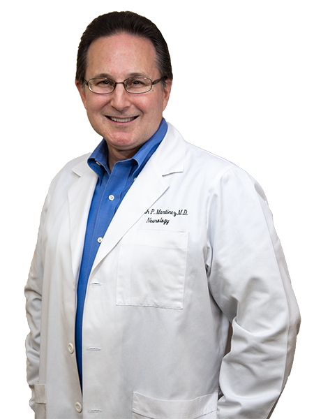 Dr. Kenneth P. Martinez poses in a white lab coat, smiling at the camera