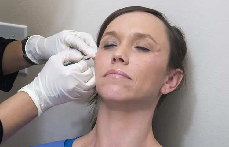 A female patient receiving an injection at her temple for blepharospasm
